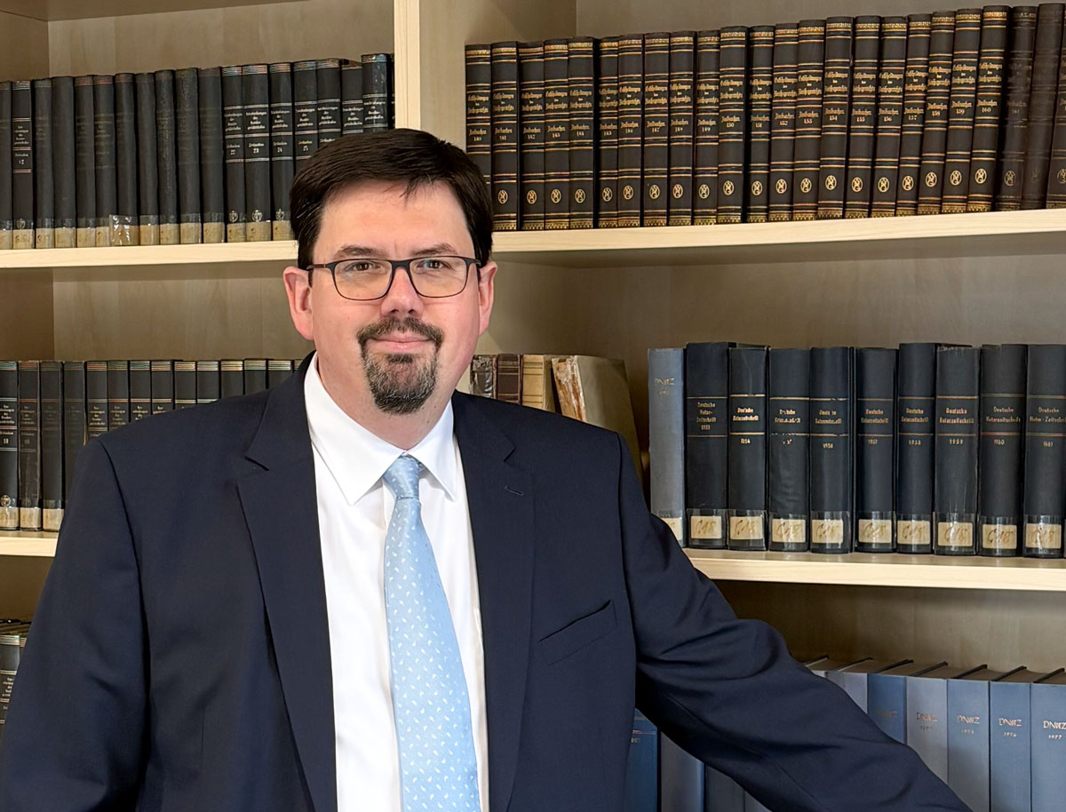 Notar Marcus Rolfes, Kanzlei Hude, an einem Buchregal mit Gesetzestexten